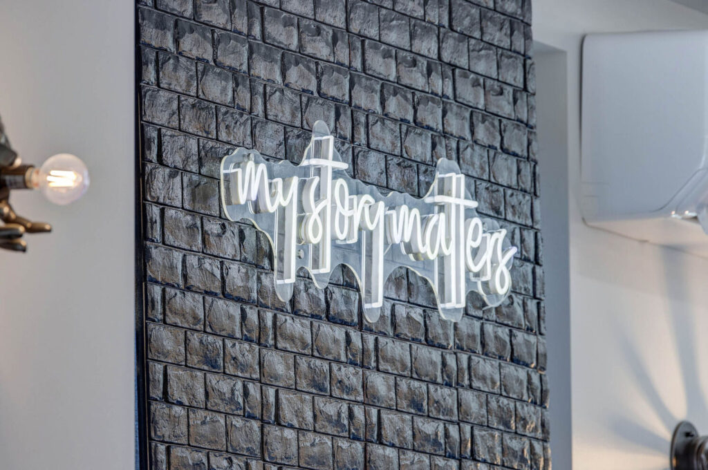 Black Brick Wall with light up sign thats says "my story matter"