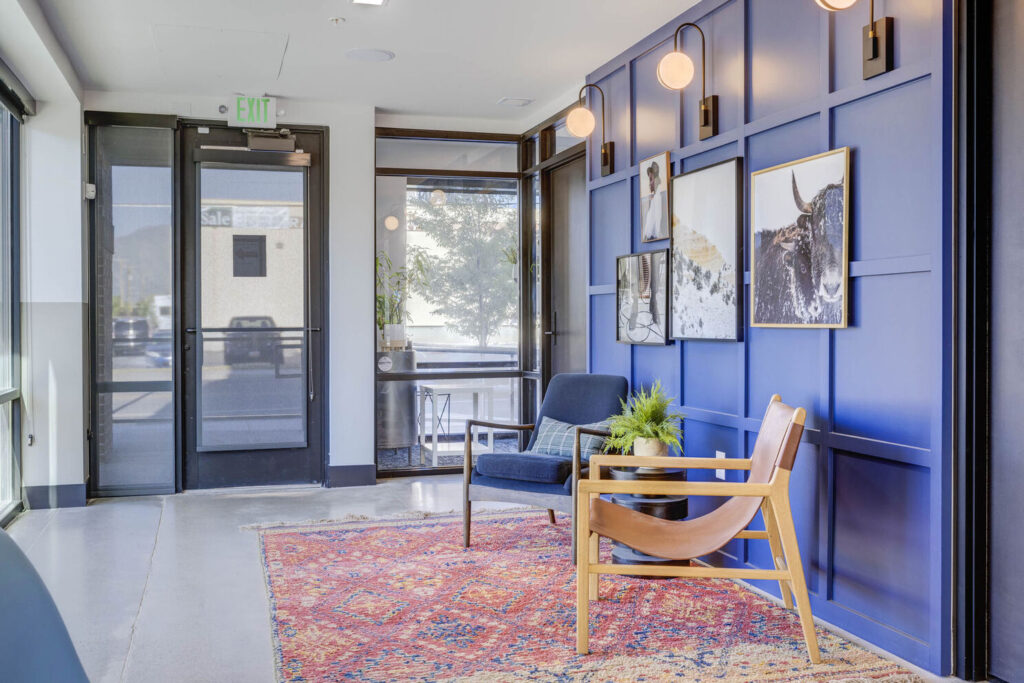 entrance to the indoor clubhouse with two seats and a blue painted backdrop wall with pictures on it