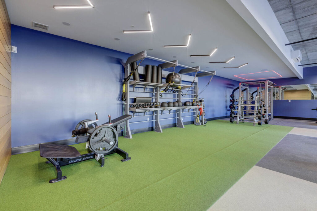 The indoor gym featuring boxing equipment, safe flooring, and spacious area for multiple individuals to work out simultaneously.