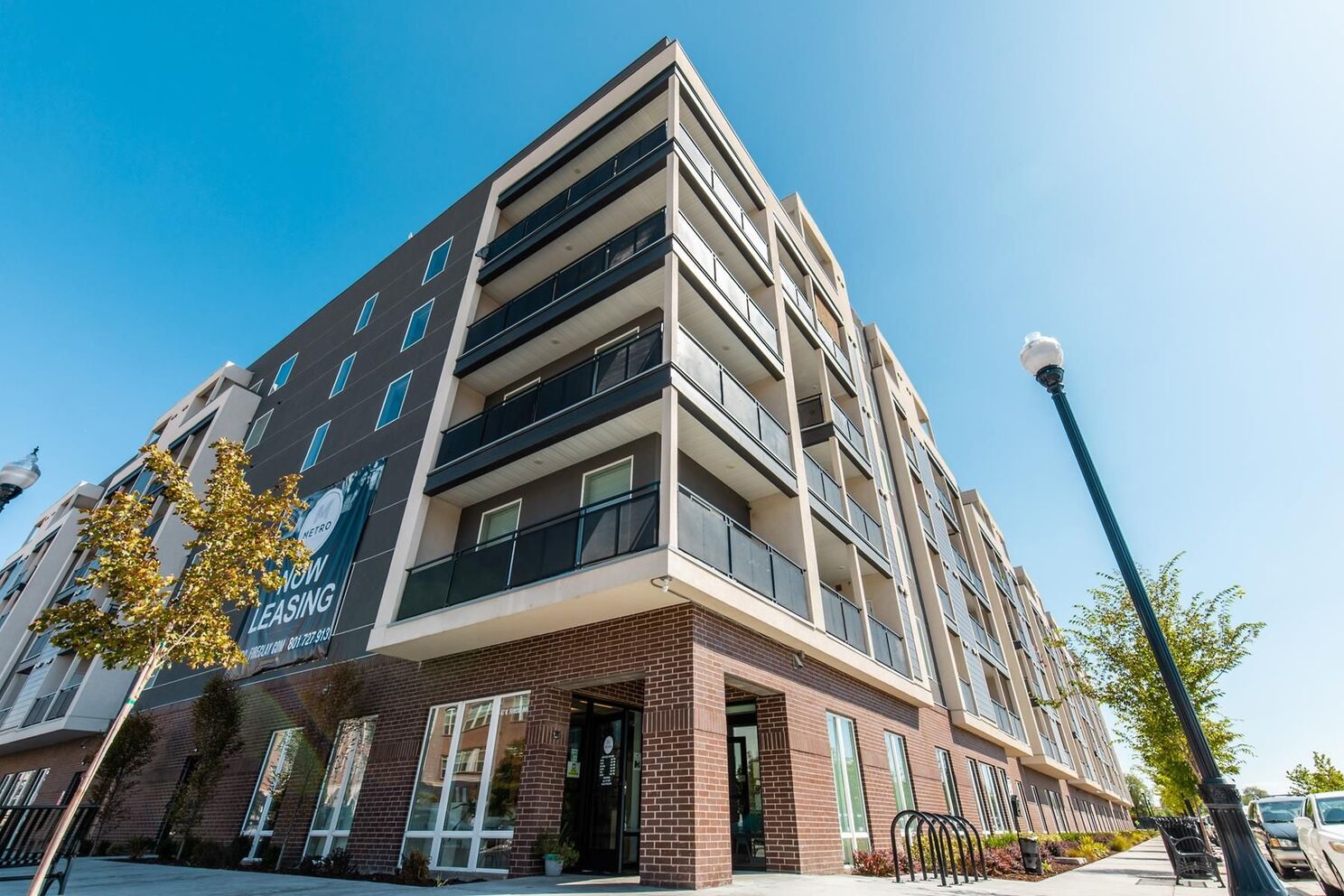 Exterior corner shot of building showcasing the tall brick building with off-white painted balconies