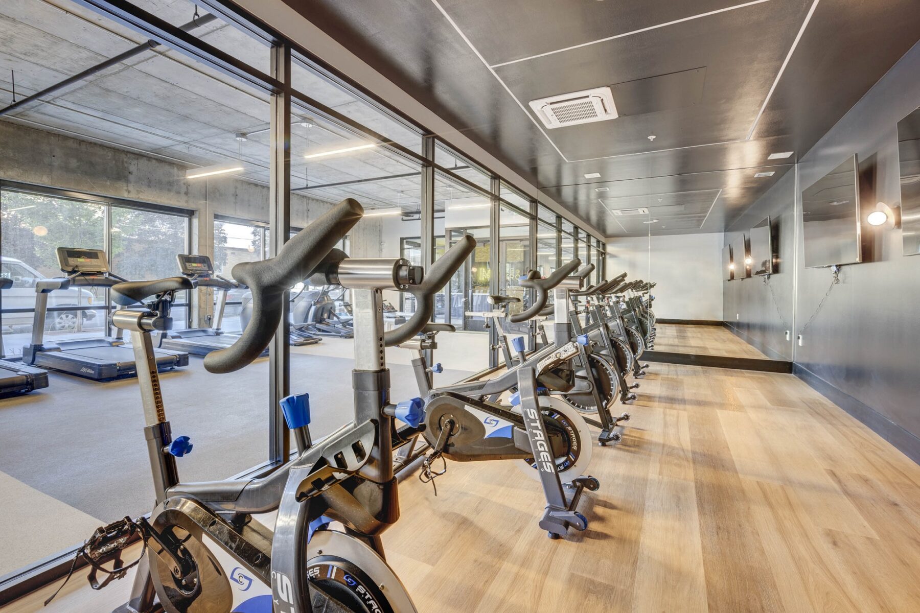 several Stationary bikes inside the indoor gym on light brown wooden floor