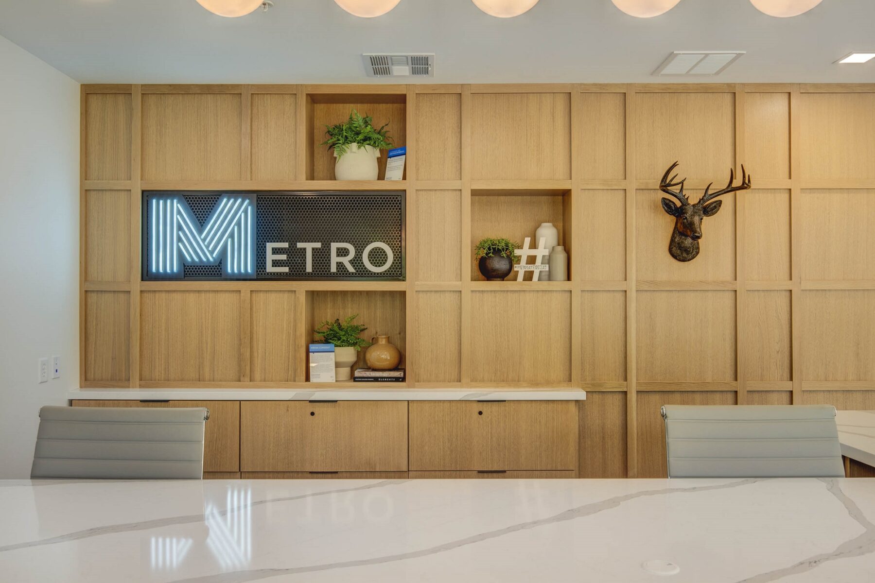 back wooden wall at clubhouse with light up blue metro logo sign and the island countertop
