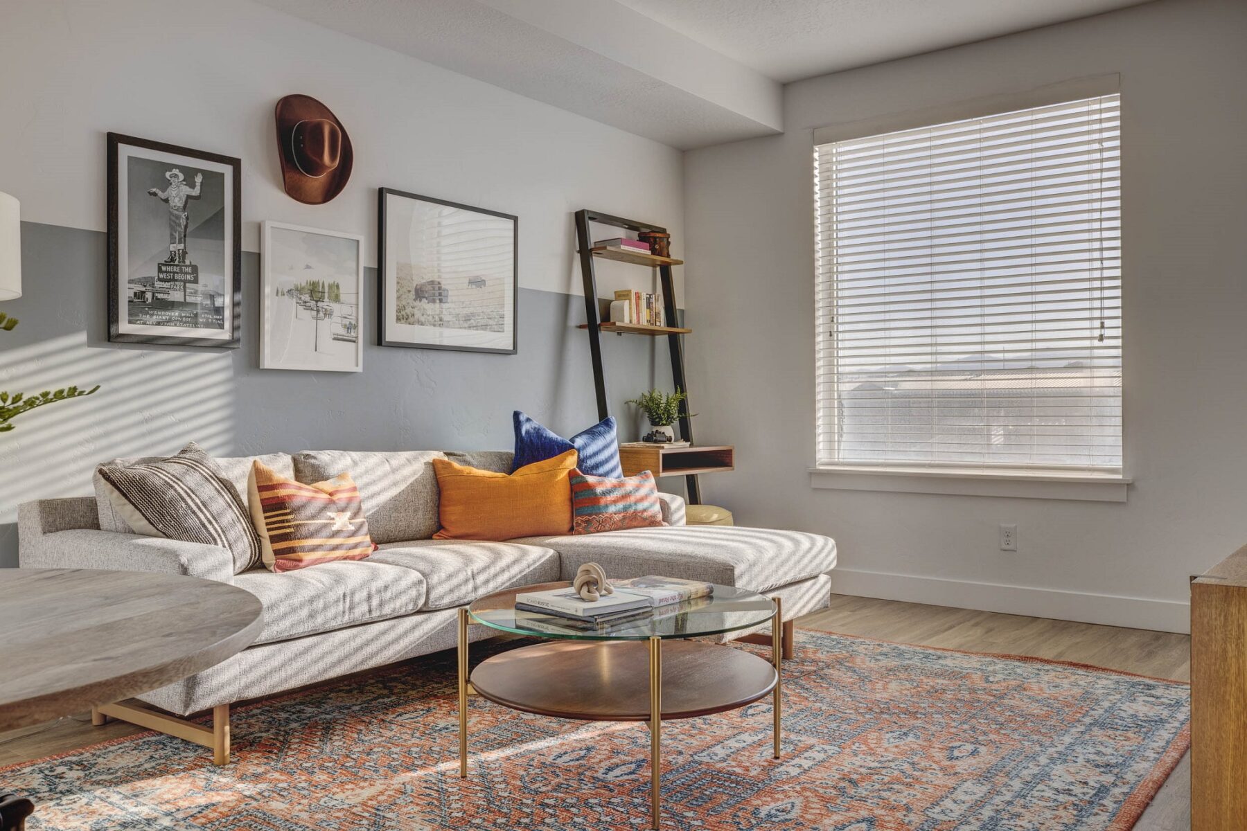 neutral-colored living room with stylish decor featuring a large window that allows for ample natural light and warmth