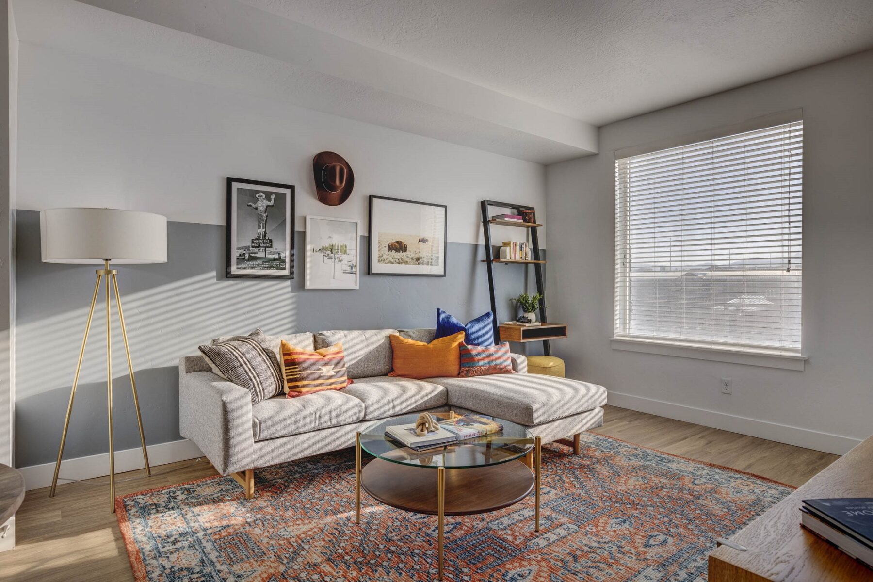 view of living room with big window, L-shaped couch and lamp